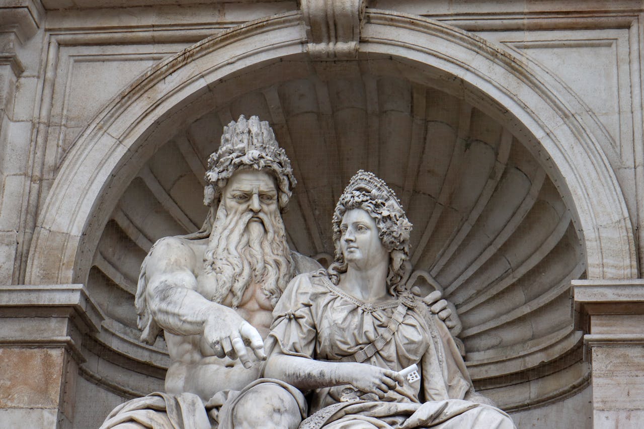 Close-up of a detailed marble sculpture depicting mythological figures under an ornate archway.